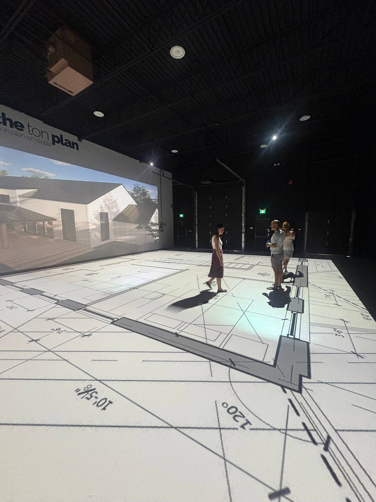 Clients qui marchent dans leur plan projeté en grandeur réelle au studio Marche ton plan